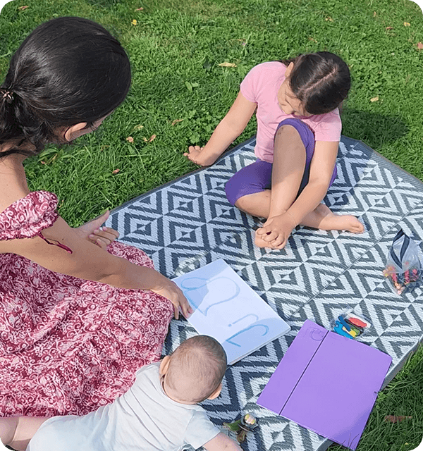 Children and adult homeschooling outdoors in a park